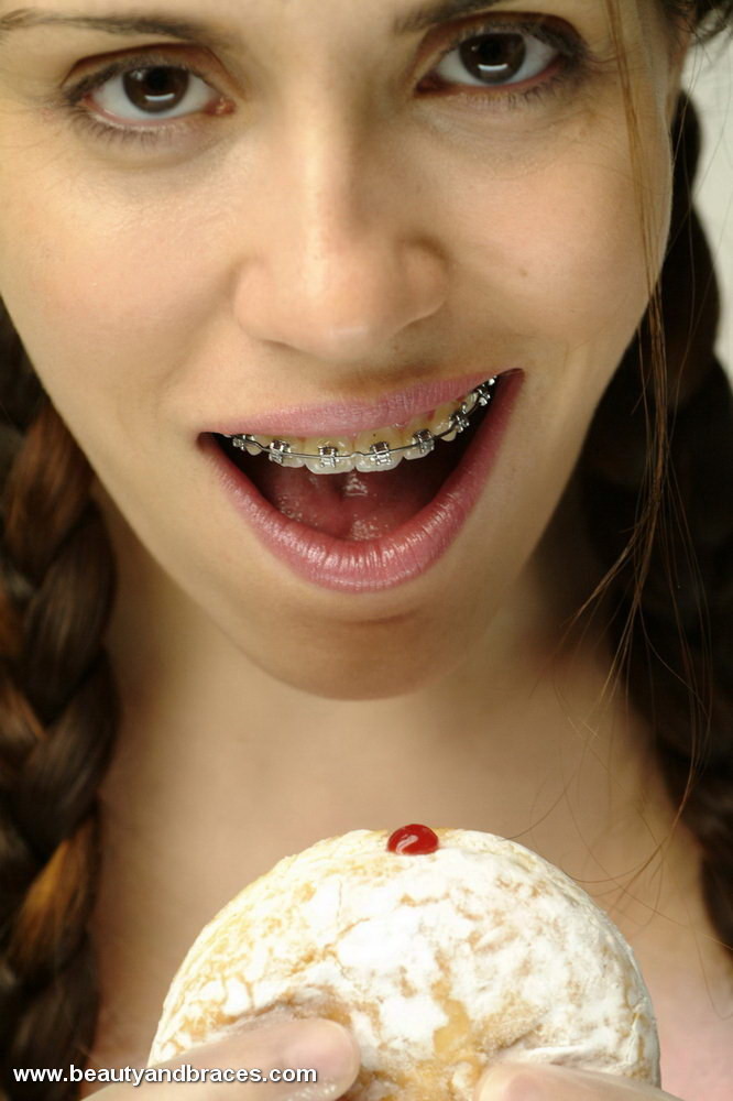 Teen mit Zöpfen und Zahnspange stopft einen Donut in ihren sexy Mund
 #74900316