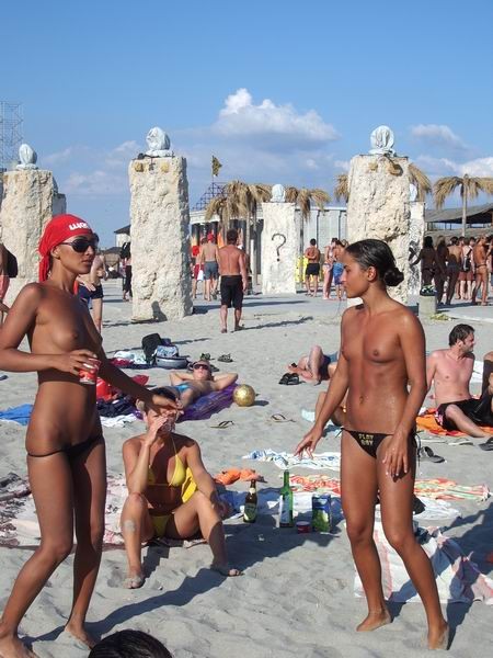Une brune s'amuse à être nue sur une plage publique.
 #72246768