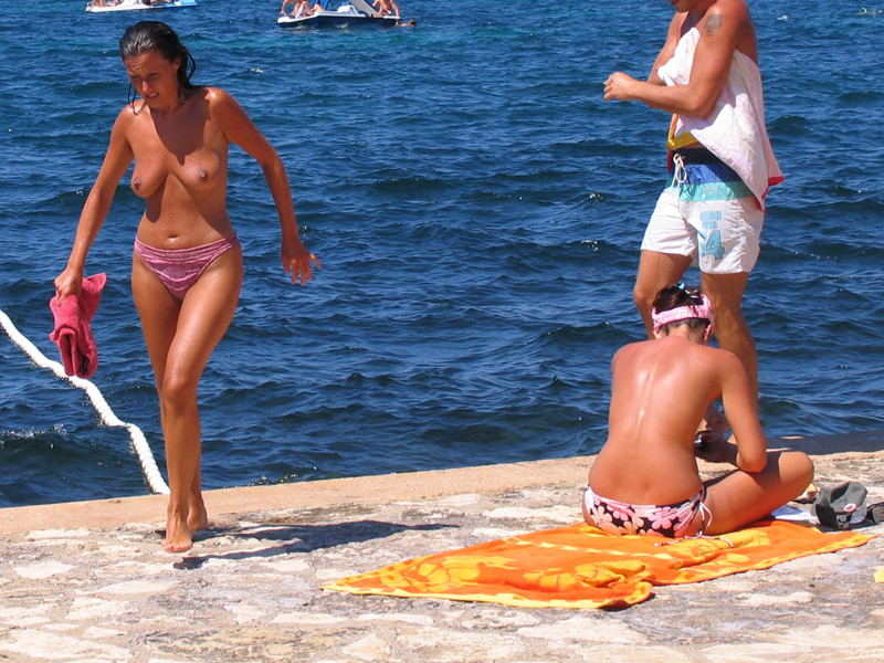 Une brune s'amuse à être nue sur une plage publique.
 #72246824