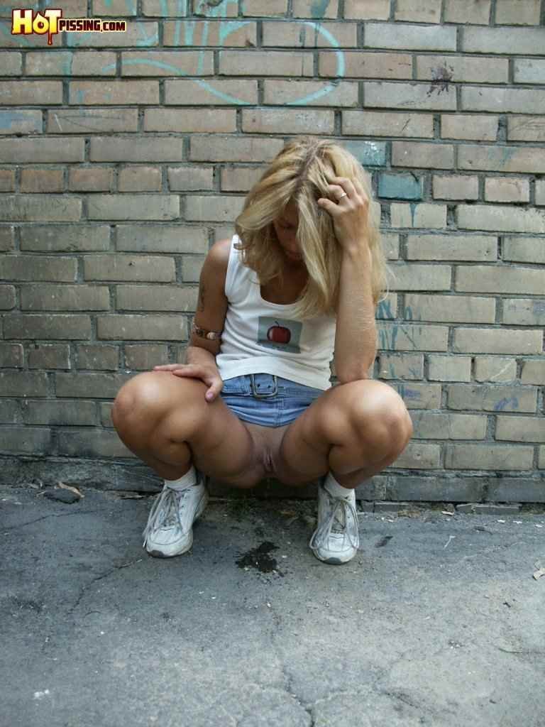 Cute girl pissing on the side walk #76593262