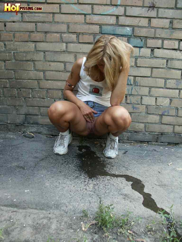 Cute girl pissing on the side walk #76593304