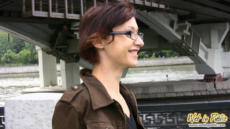 Nervous grin of a girl in glasses who pissed in her jeans in public #78594999