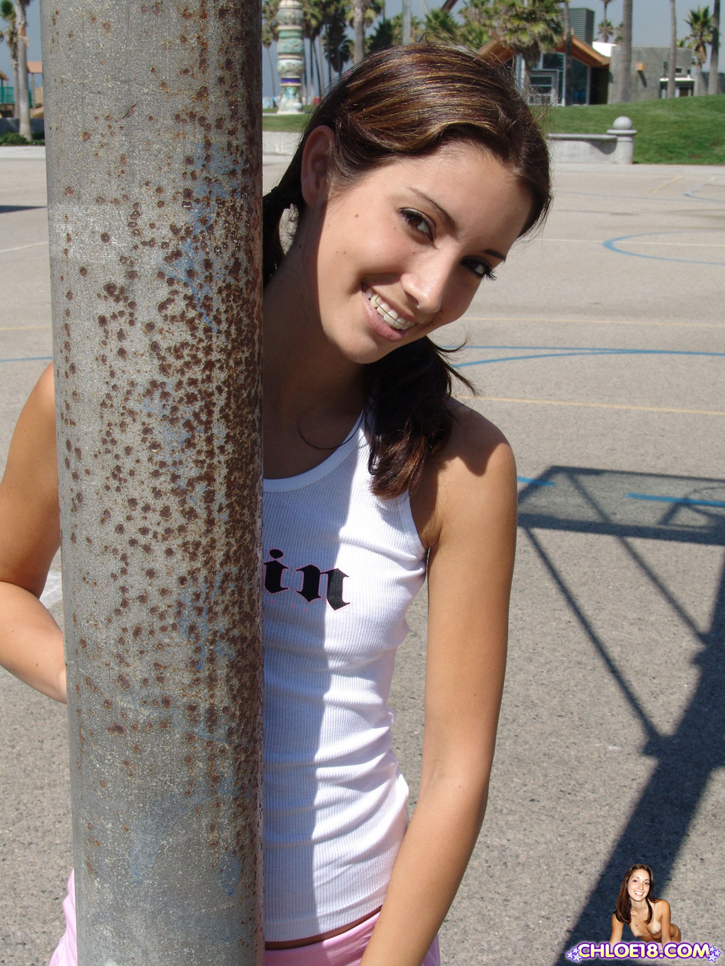 Cute teen outside by a palm tree showing skin #67822960