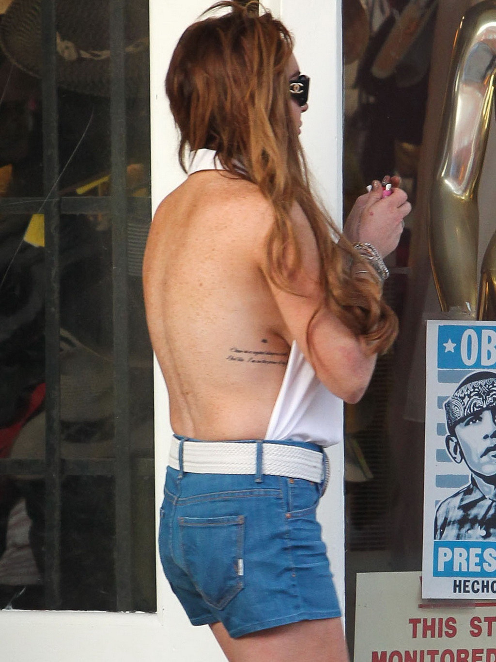 Lindsay Lohan, sans soutien-gorge, montre le côté de son sein lors d'un shopping à Venise.
 #75253879