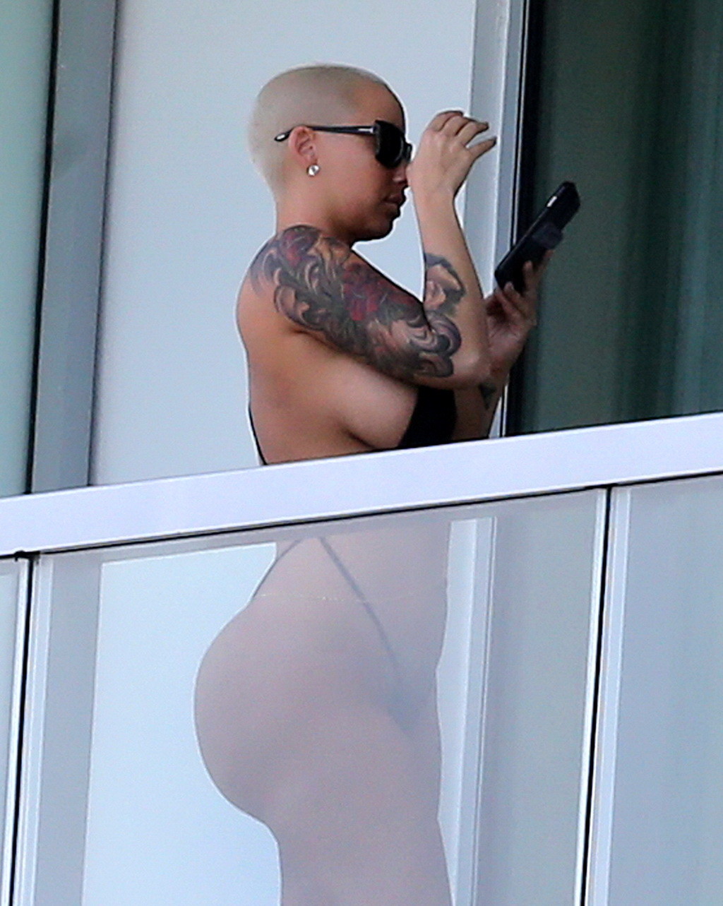 Amber rose montre ses fesses rondes dans un minuscule monokini noir sur le balcon d'un hôtel.
 #75174842