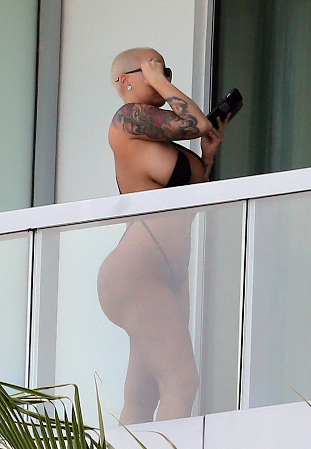 Amber rose montre ses fesses rondes dans un minuscule monokini noir sur le balcon d'un hôtel.
 #75174862