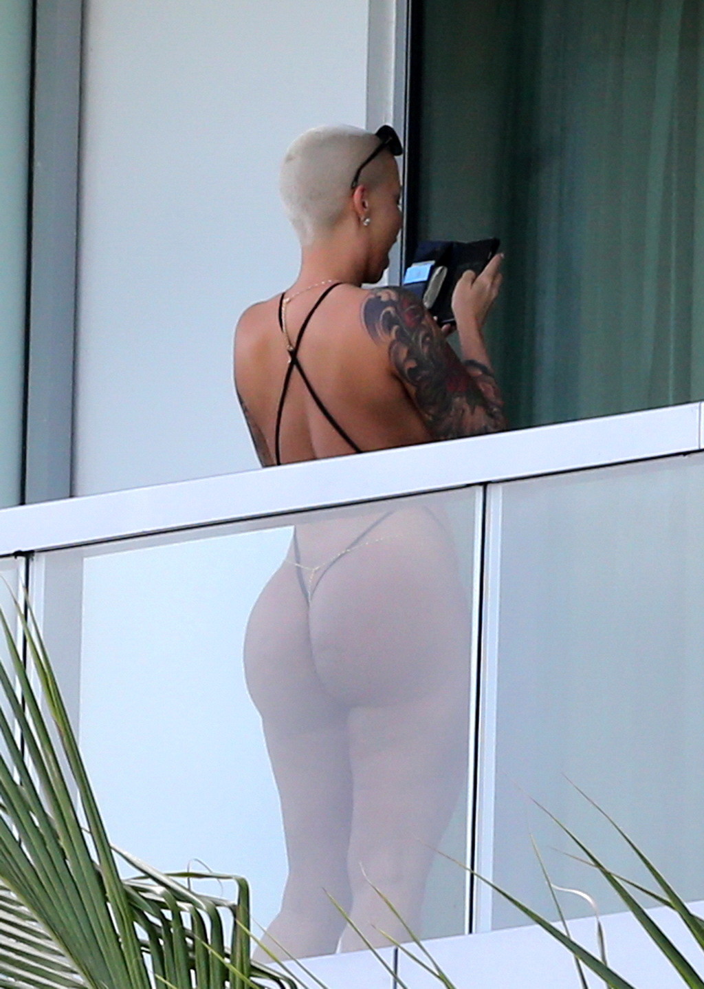 Amber rose montre ses fesses rondes dans un minuscule monokini noir sur le balcon d'un hôtel.
 #75174898