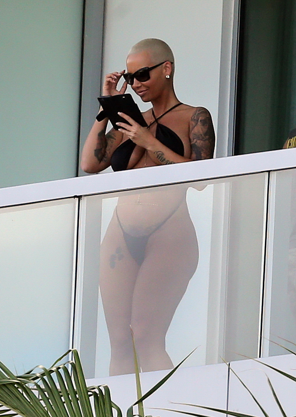 Amber rose montre ses fesses rondes dans un minuscule monokini noir sur le balcon d'un hôtel.
 #75174906