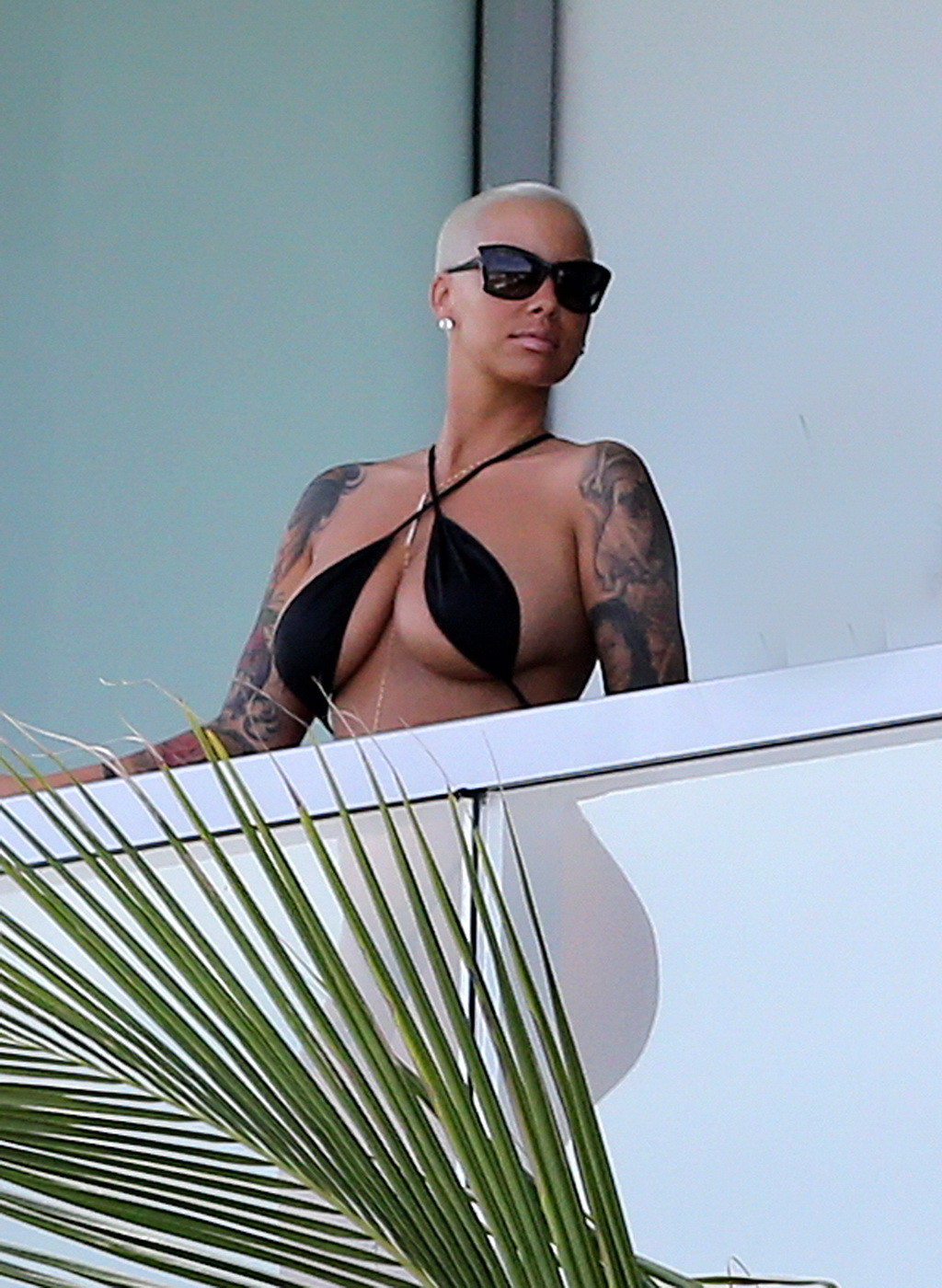 Amber rose montre ses fesses rondes dans un minuscule monokini noir sur le balcon d'un hôtel.
 #75174909