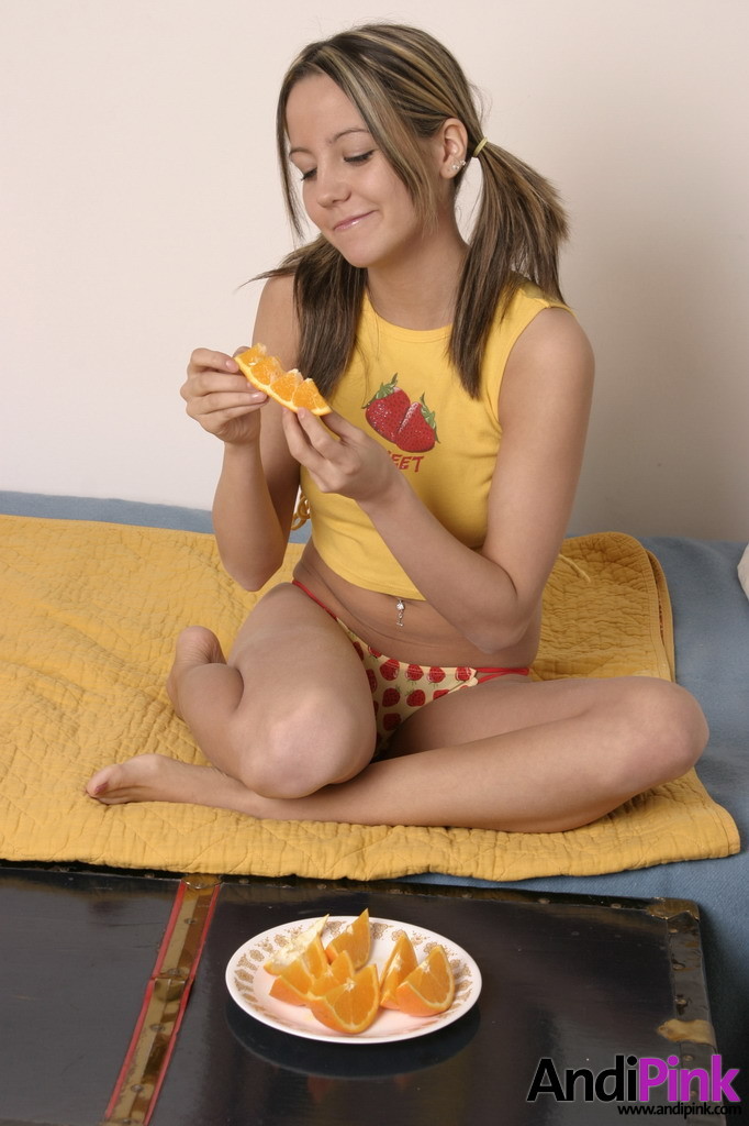 Linda chica joven con coletas comer naranja
 #67208632