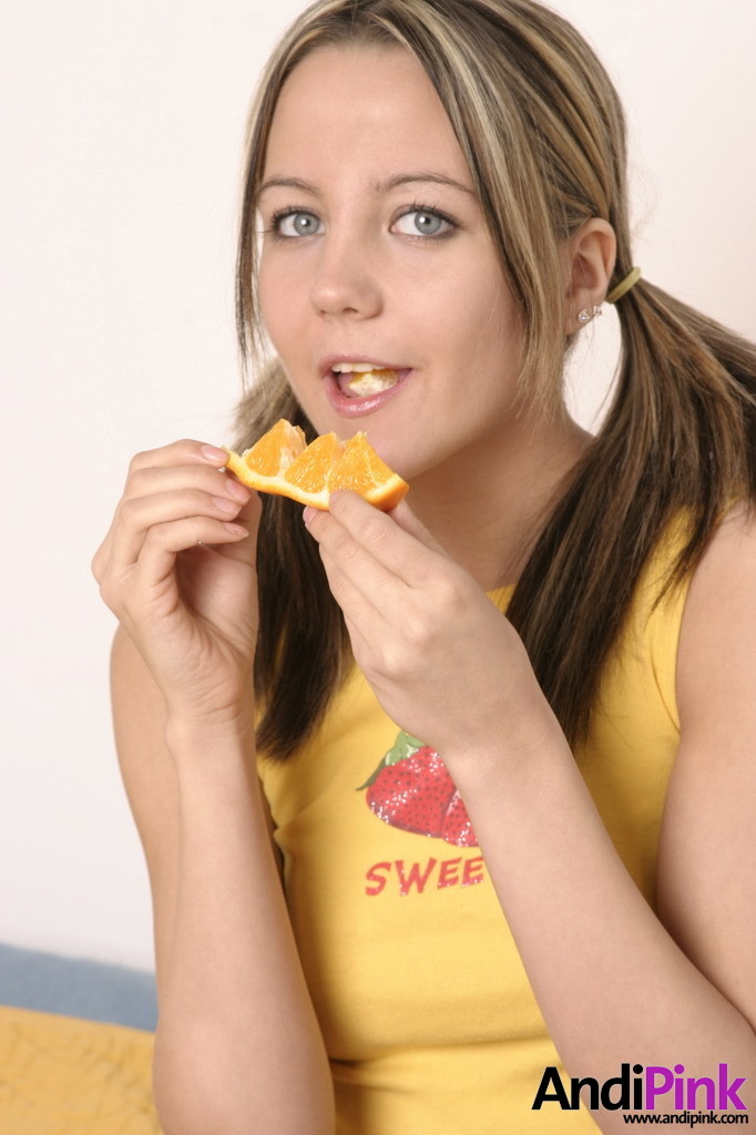 Linda chica joven con coletas comer naranja
 #67208650
