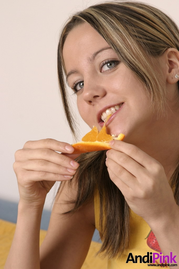 Linda chica joven con coletas comer naranja
 #67208723