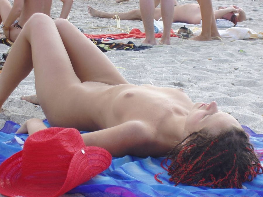 Une belle jeune au visage frais joue nue sur la plage
 #72257090