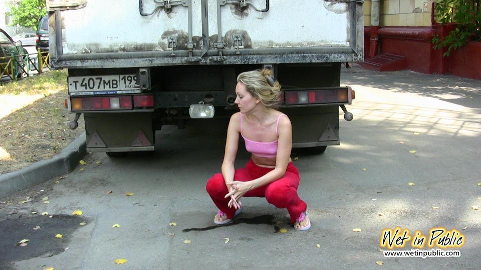 Cutie hides behind a truck to pee right through her red sporty pants #73239870