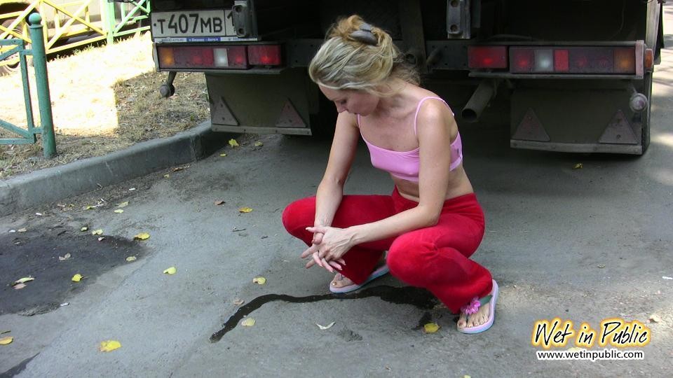 La chica se esconde detrás de un camión para orinar a través de sus pantalones deportivos rojos
 #73239900