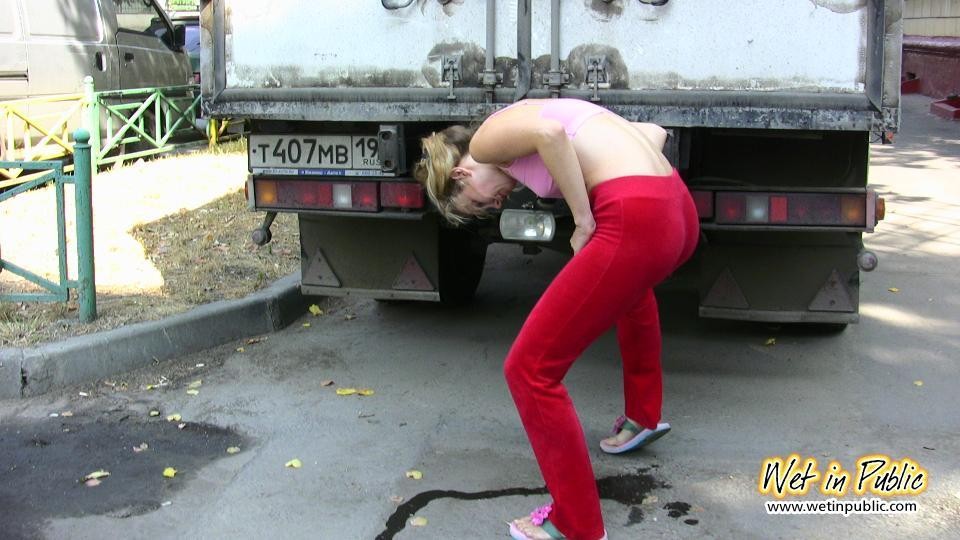 La chica se esconde detrás de un camión para orinar a través de sus pantalones deportivos rojos
 #73239907