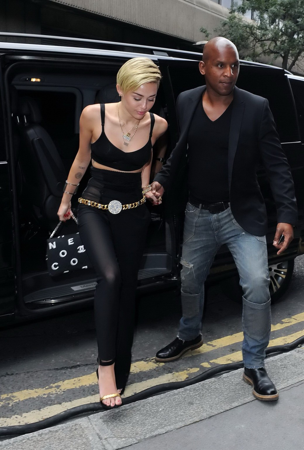 Miley Cyrus sans culotte portant un pantalon noir transparent et un débardeur devant chez elle 
 #75219325