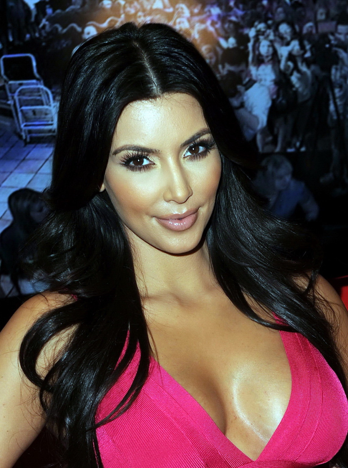Kim Kardashian busty in tight pink dress posing alongside with her wax dummy at Madame Tus