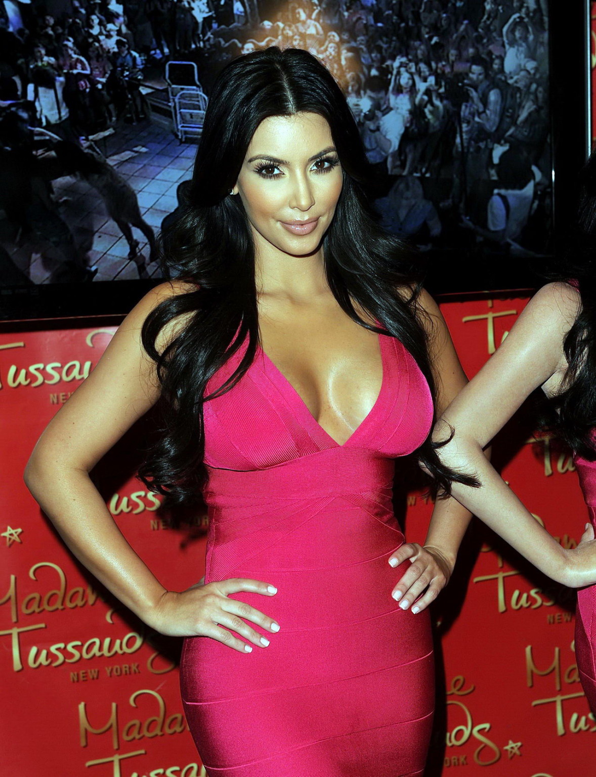 Kim Kardashian en robe rose moulante posant avec son mannequin de cire chez Madame Tus.
 #75342618