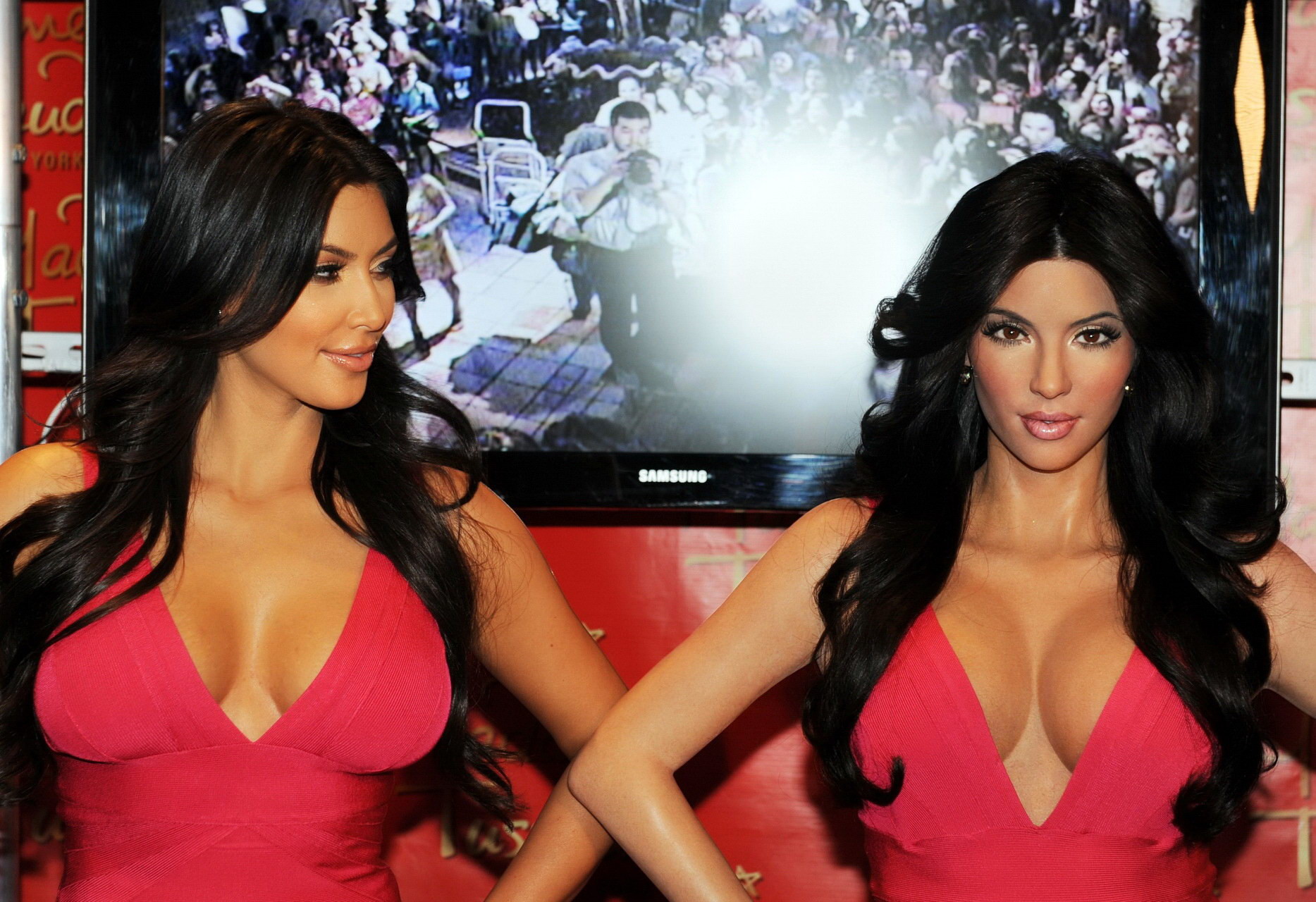 Kim Kardashian vollbusig im engen rosa Kleid posiert mit ihrer Wachspuppe bei Madame Tus
 #75342695
