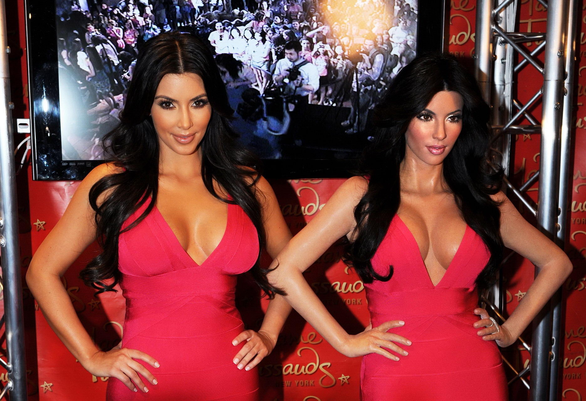 Kim Kardashian en robe rose moulante posant avec son mannequin de cire chez Madame Tus.
 #75342714