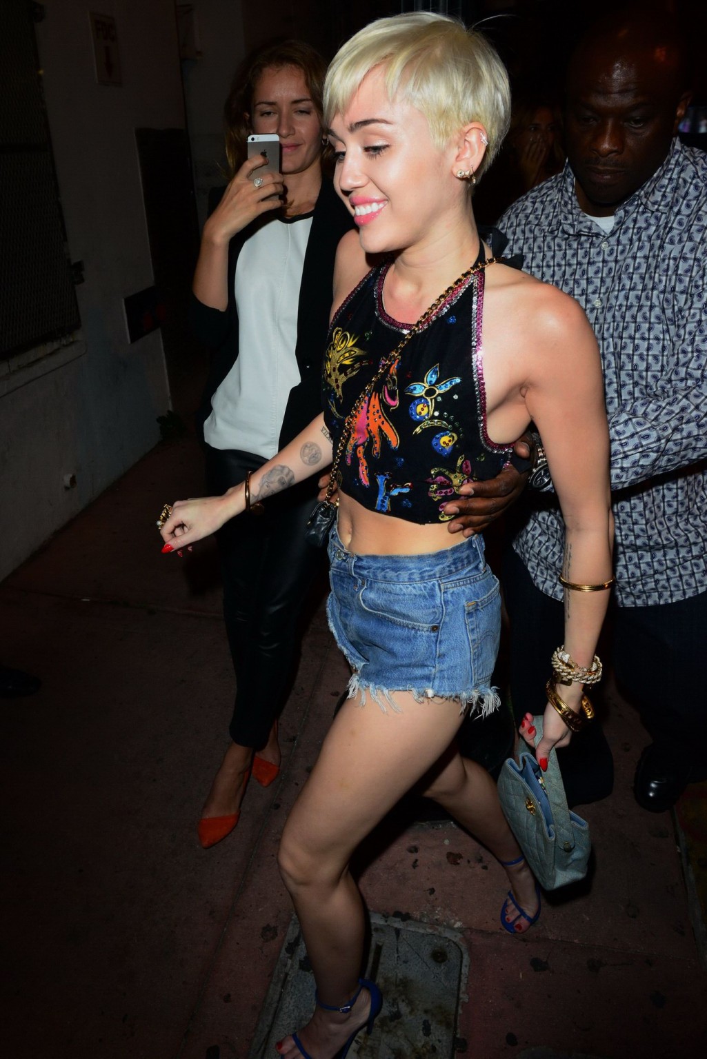 Miley cyrus en pantalones cortos de mezclilla y la parte superior del vientre en el club nocturno cameo en miami
 #75200972