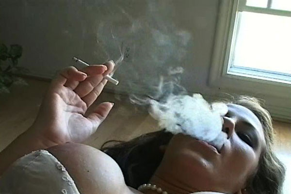 A smokin gal bedecked in pearls emits smoke curls into the air around her as she #68263017
