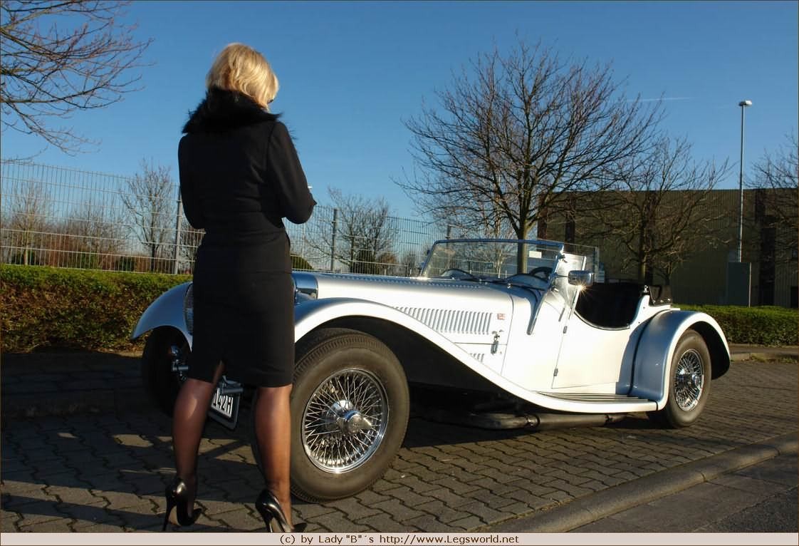 Elegante señora de las medias con el coche retro caliente
 #76477233