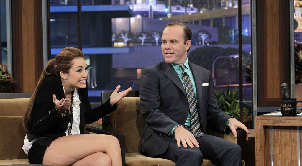 Miley Cyrusがテレビ番組で黒のミニスカートを履いて脚を見せている。
 #75354797
