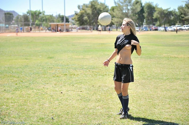 Blonde Fußball-Mädchen blinkt ihre Waren auf dem Feld
 #67349373