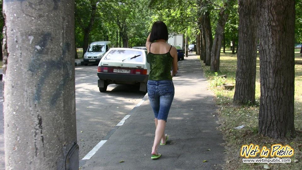 Une jolie fille mouille son jean, sa culotte et se change derrière des buissons. #73239171