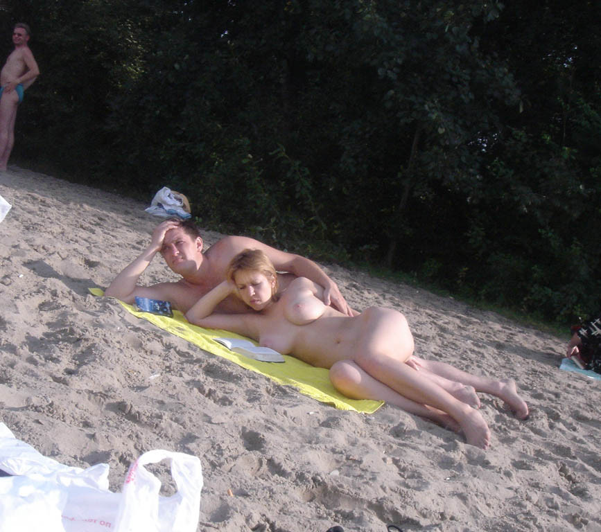 Una joven nudista de pelo oscuro se broncea por completo en la playa
 #72253591
