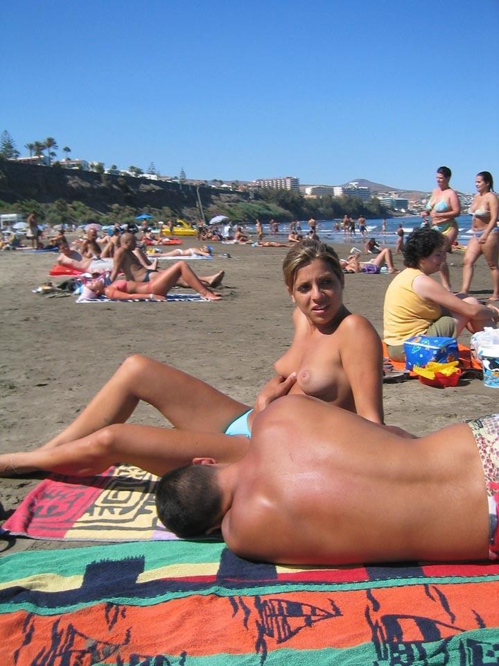 Jeune nudiste aux cheveux foncés bronzant sur toute la plage.
 #72253615