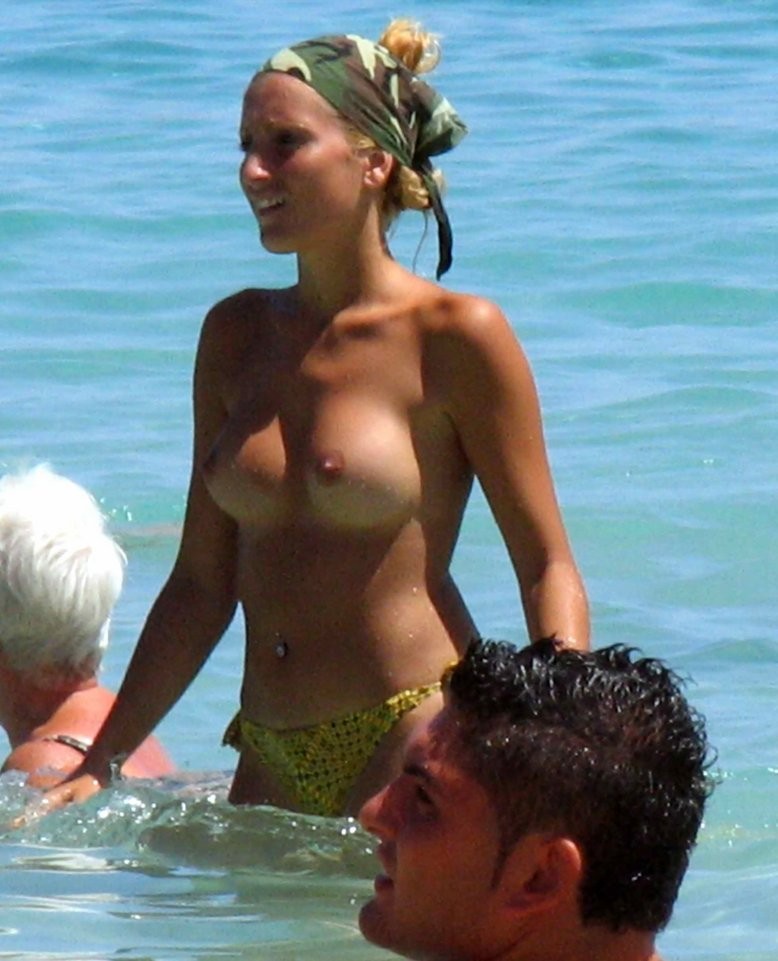 Una joven nudista de pelo oscuro se broncea por completo en la playa
 #72253673