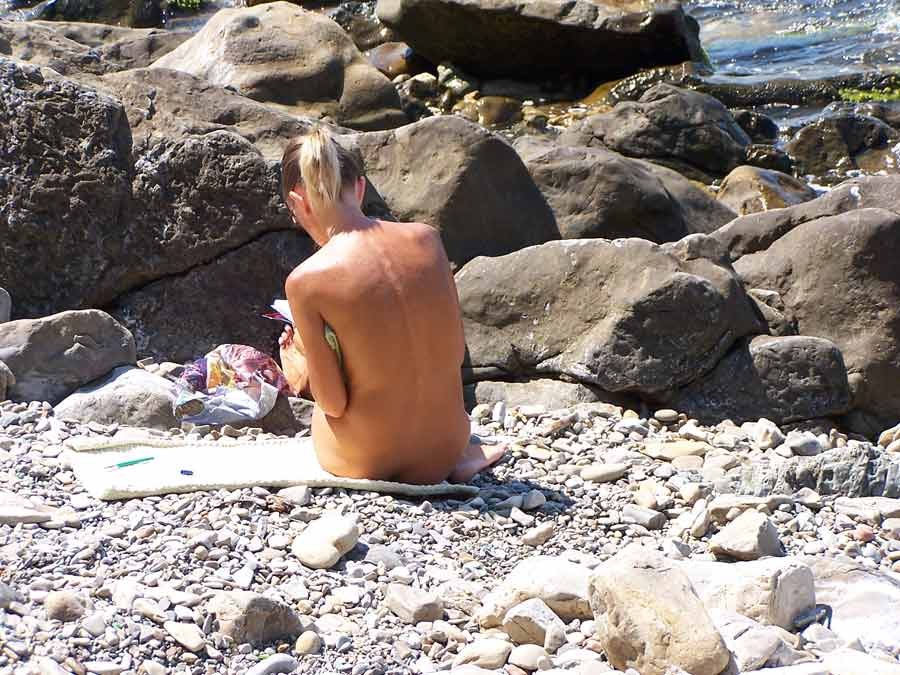 Brunette nudist strips down naked at a public beach #72249009