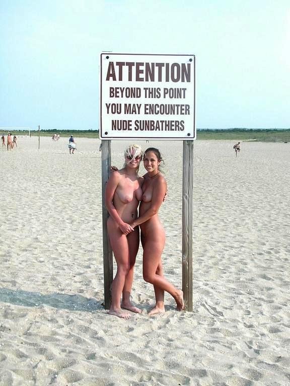 Brunette nudist strips down naked at a public beach #72249045