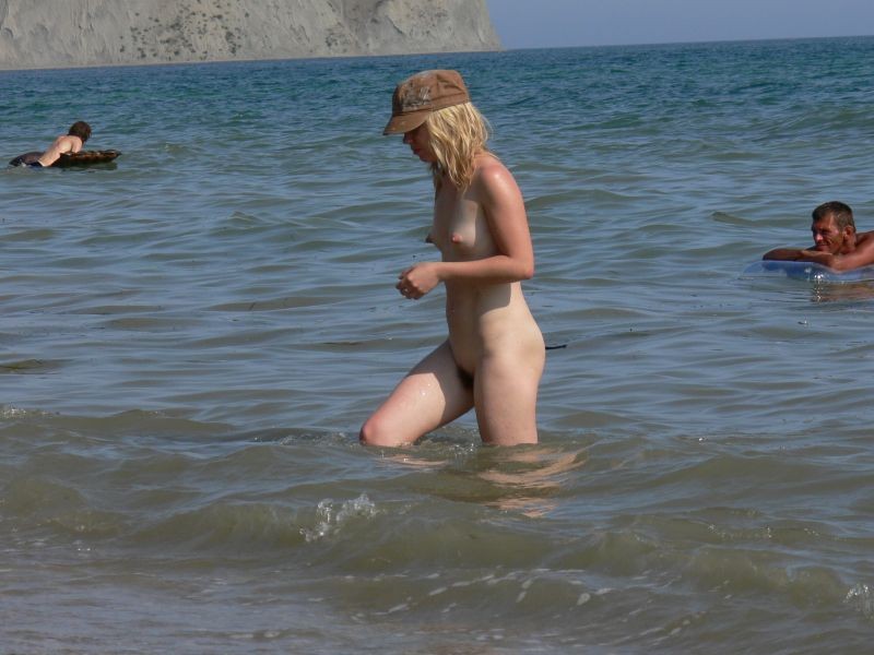 Brunette nudist strips down naked at a public beach #72249048