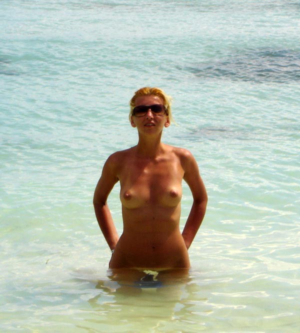Brünette Nudistin zieht sich am öffentlichen Strand nackt aus
 #72249051