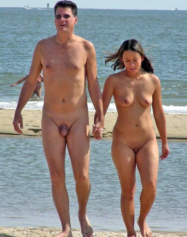 Amici nudi giocano in una spiaggia pubblica
 #72244013