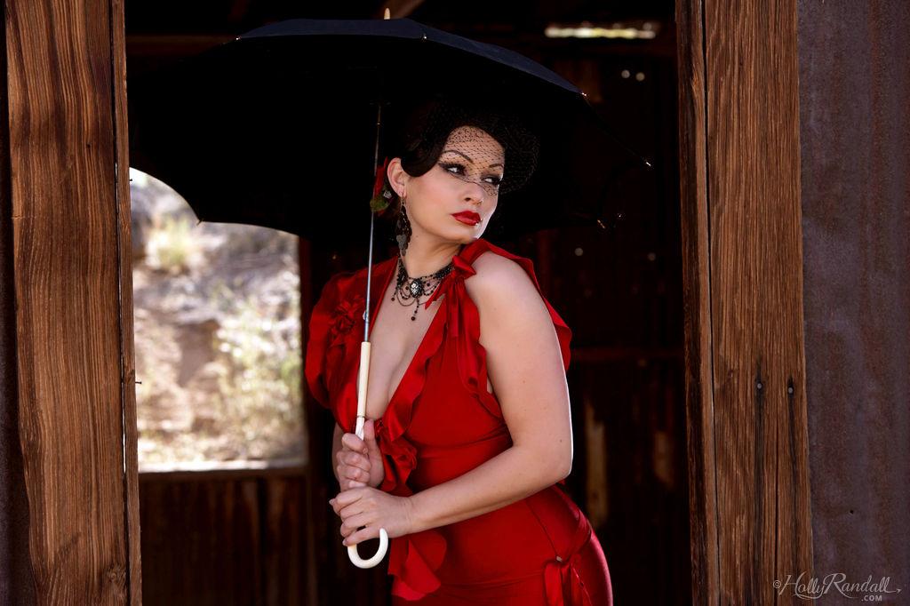 Vollbusiger Pinup-Star Aria Giovanni entblößt ihre Brüste in einem roten Kleid
 #53271463