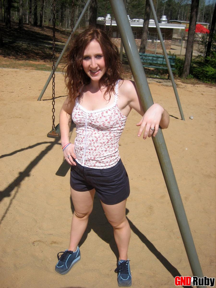 Ruby, la pelirroja que hace un striptease, juega en el columpio del parque público
 #59948478