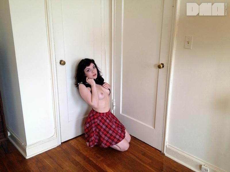 Une jolie pin-up, Lilly Rose, se déshabille de sa jupe à carreaux à la maison.
 #58955157