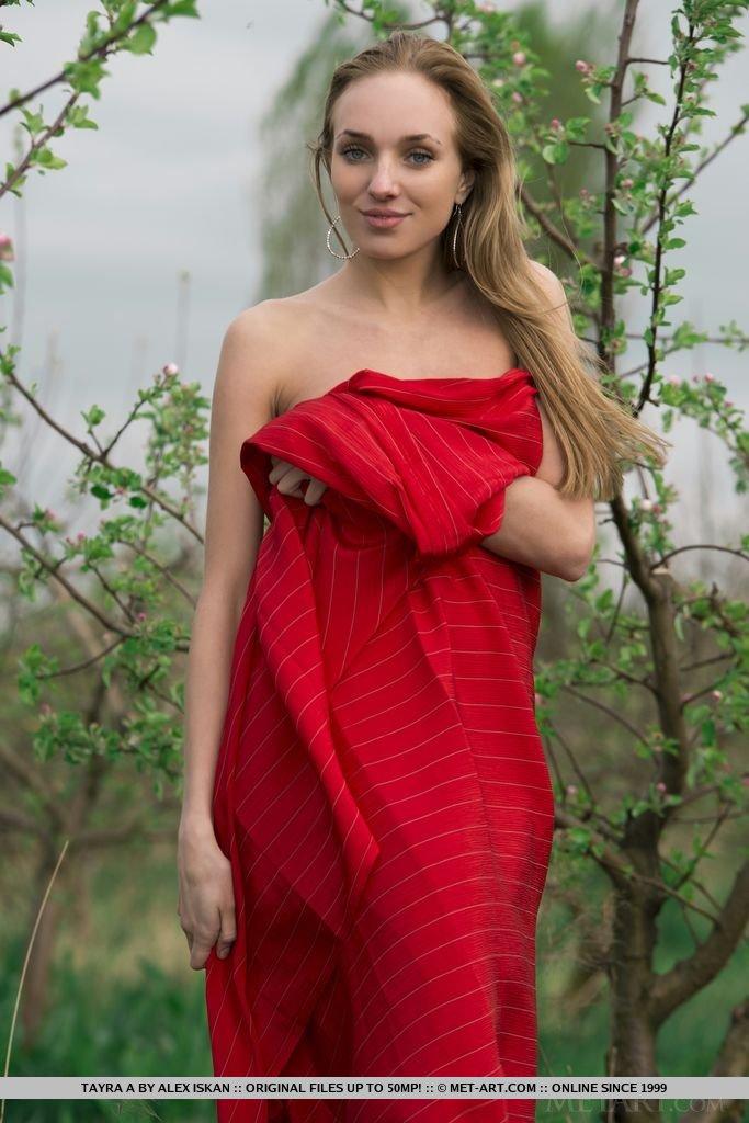Tayra a posando juguetonamente con una tela roja brillante envolviendo su delicado cuerpo desnudo
 #60076023