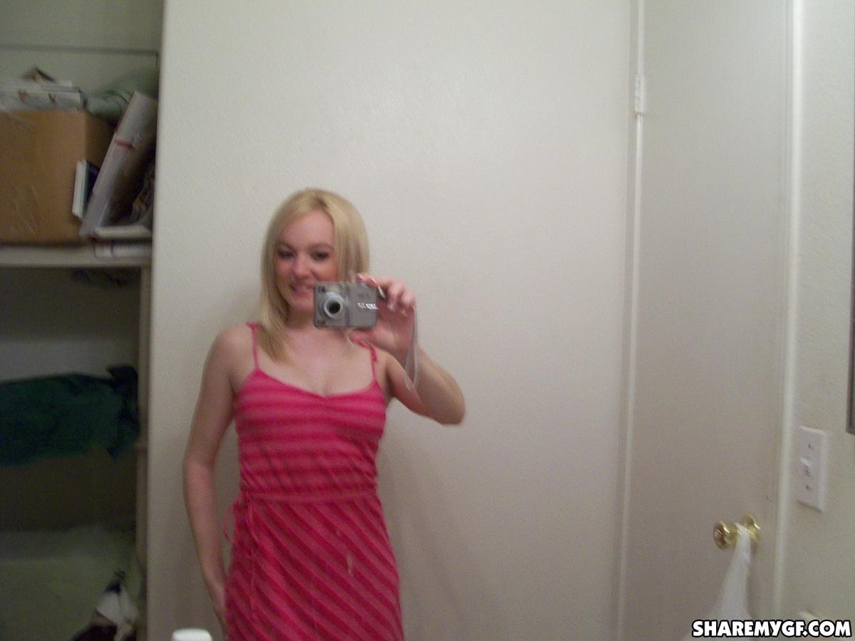 Une superbe jeune blonde prend des photos de son corps sexy dans le miroir.
 #60799094