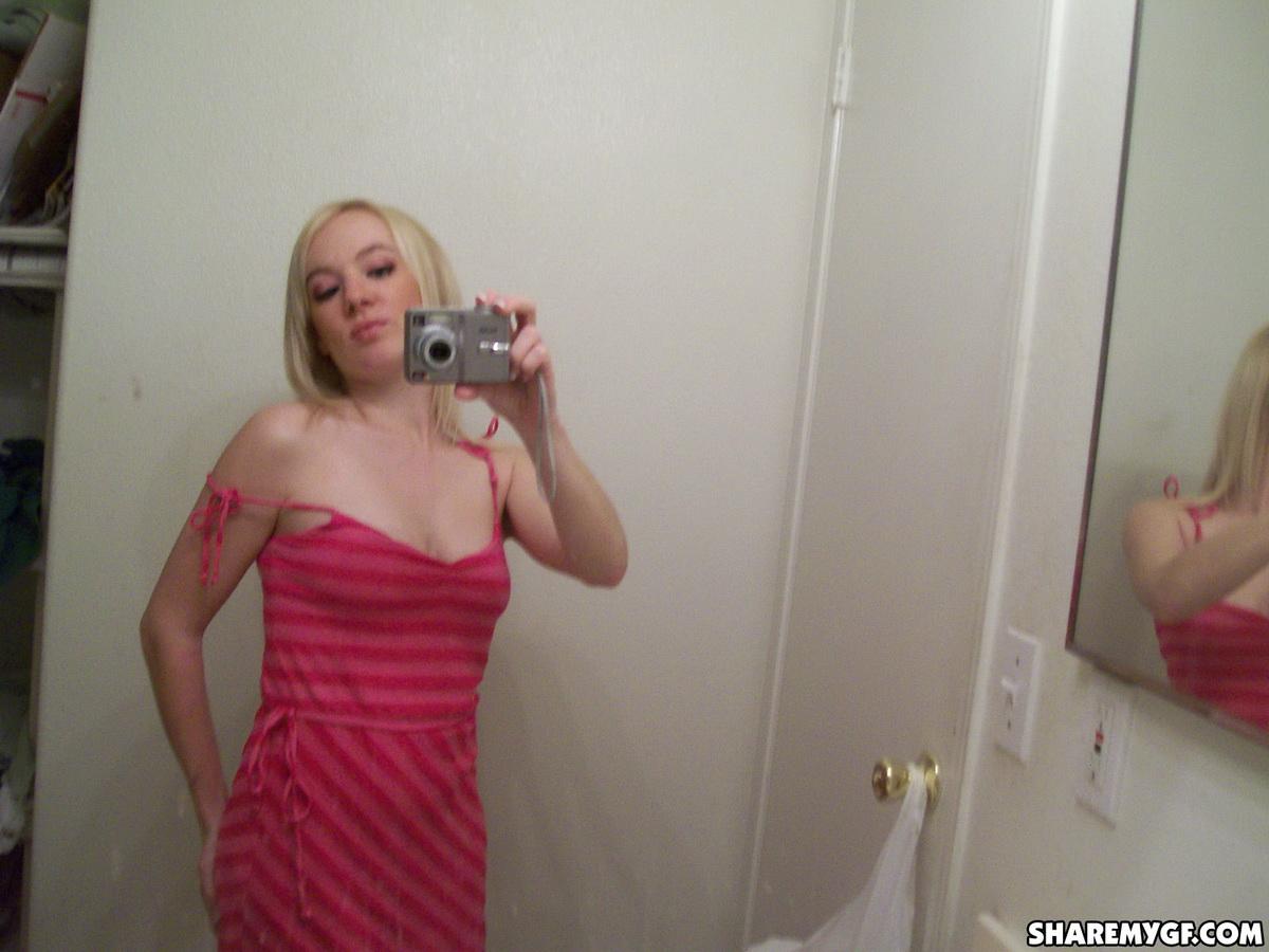 Une superbe jeune blonde prend des photos de son corps sexy dans le miroir.
 #60799128