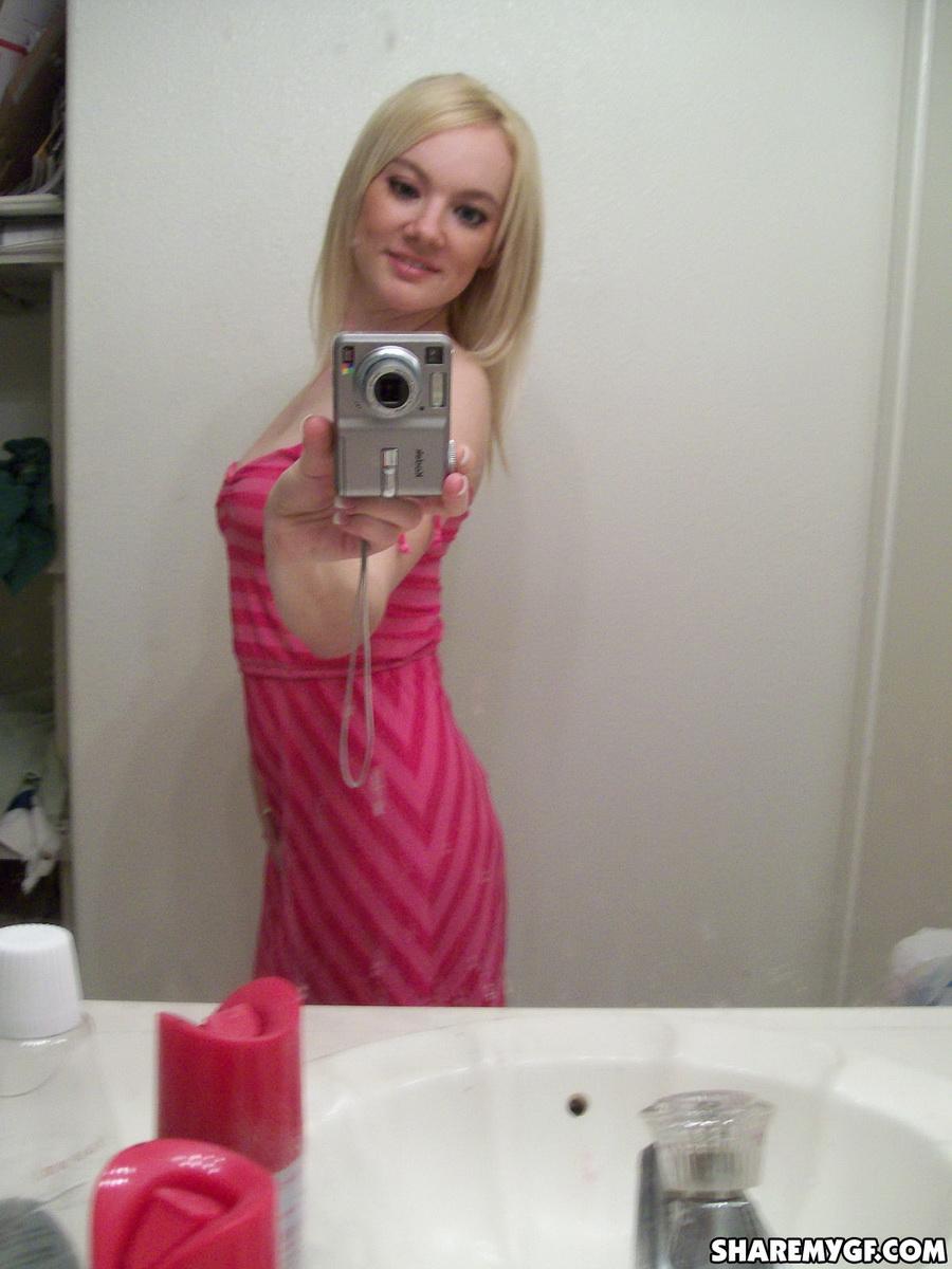 Une superbe jeune blonde prend des photos de son corps sexy dans le miroir.
 #60799143