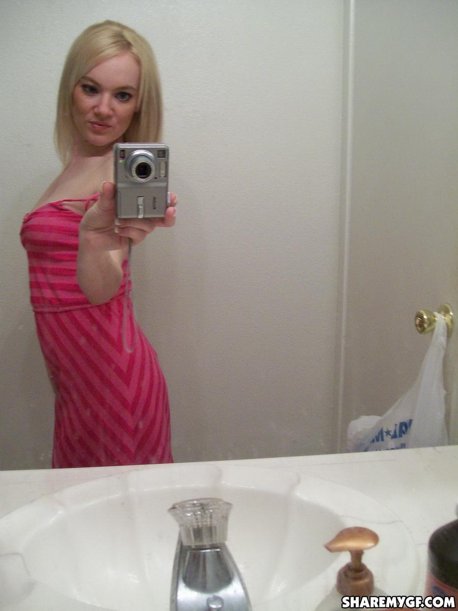 Une superbe jeune blonde prend des photos de son corps sexy dans le miroir.
 #60799160