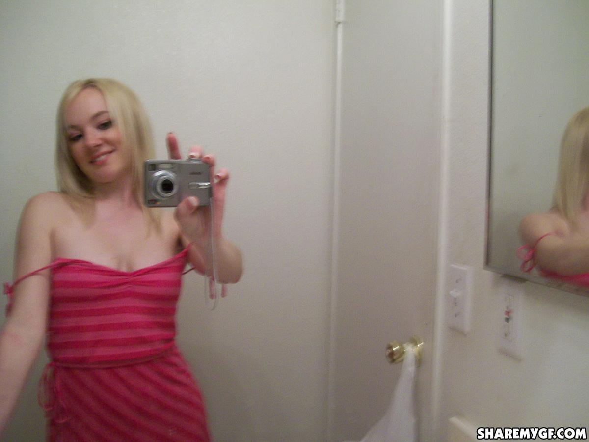 Une superbe jeune blonde prend des photos de son corps sexy dans le miroir.
 #60799179