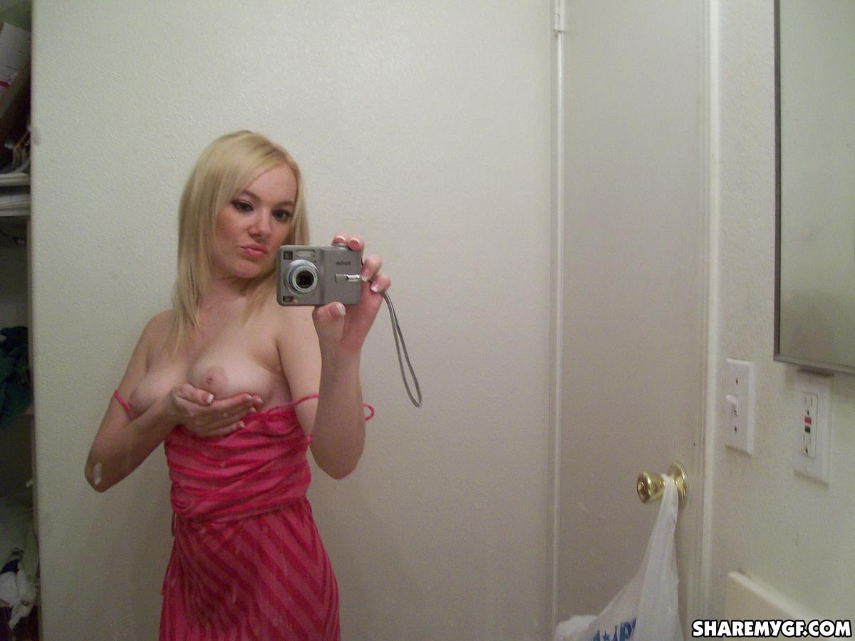 Une superbe jeune blonde prend des photos de son corps sexy dans le miroir.
 #60799214