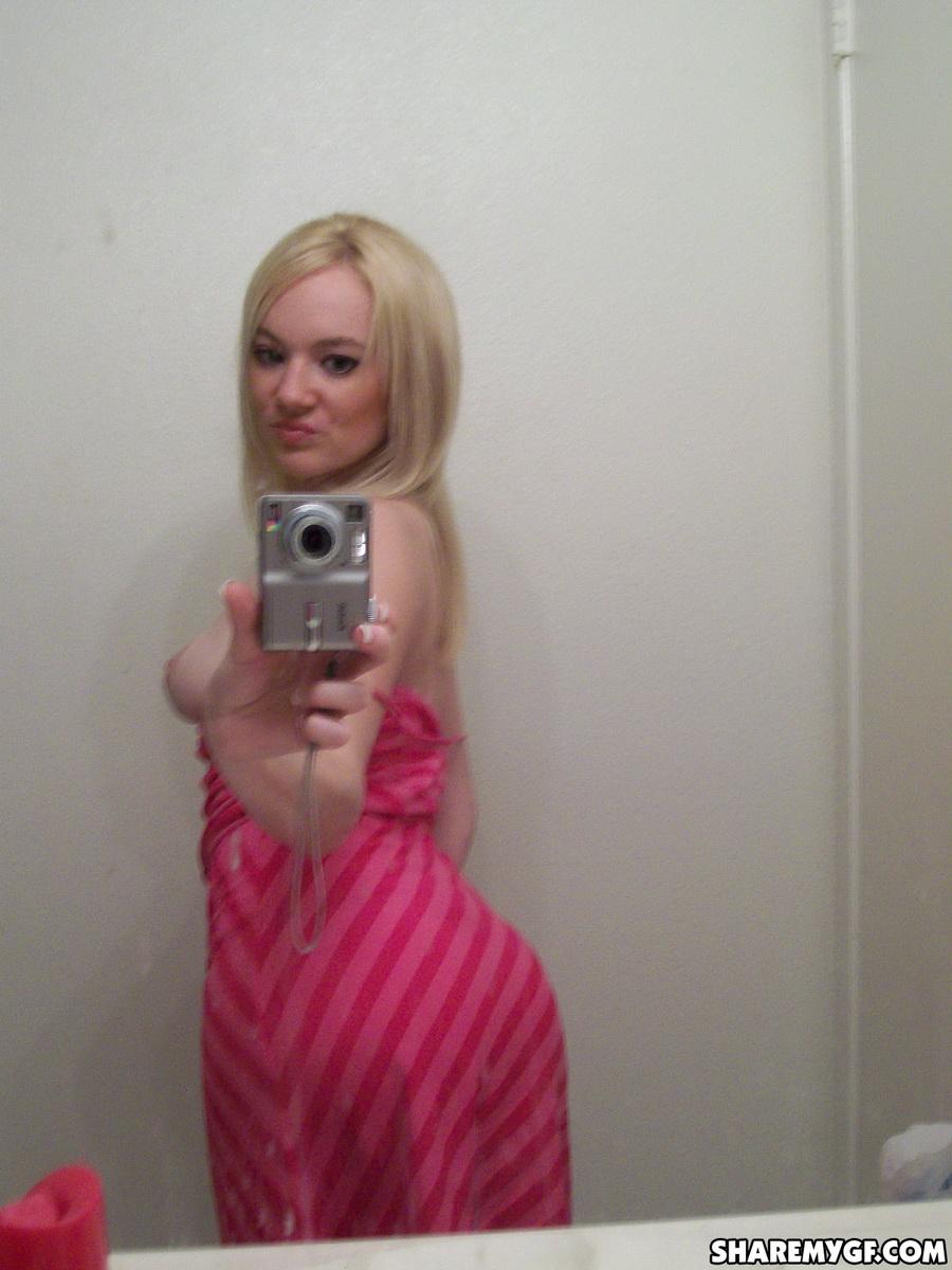 Une superbe jeune blonde prend des photos de son corps sexy dans le miroir.
 #60799228